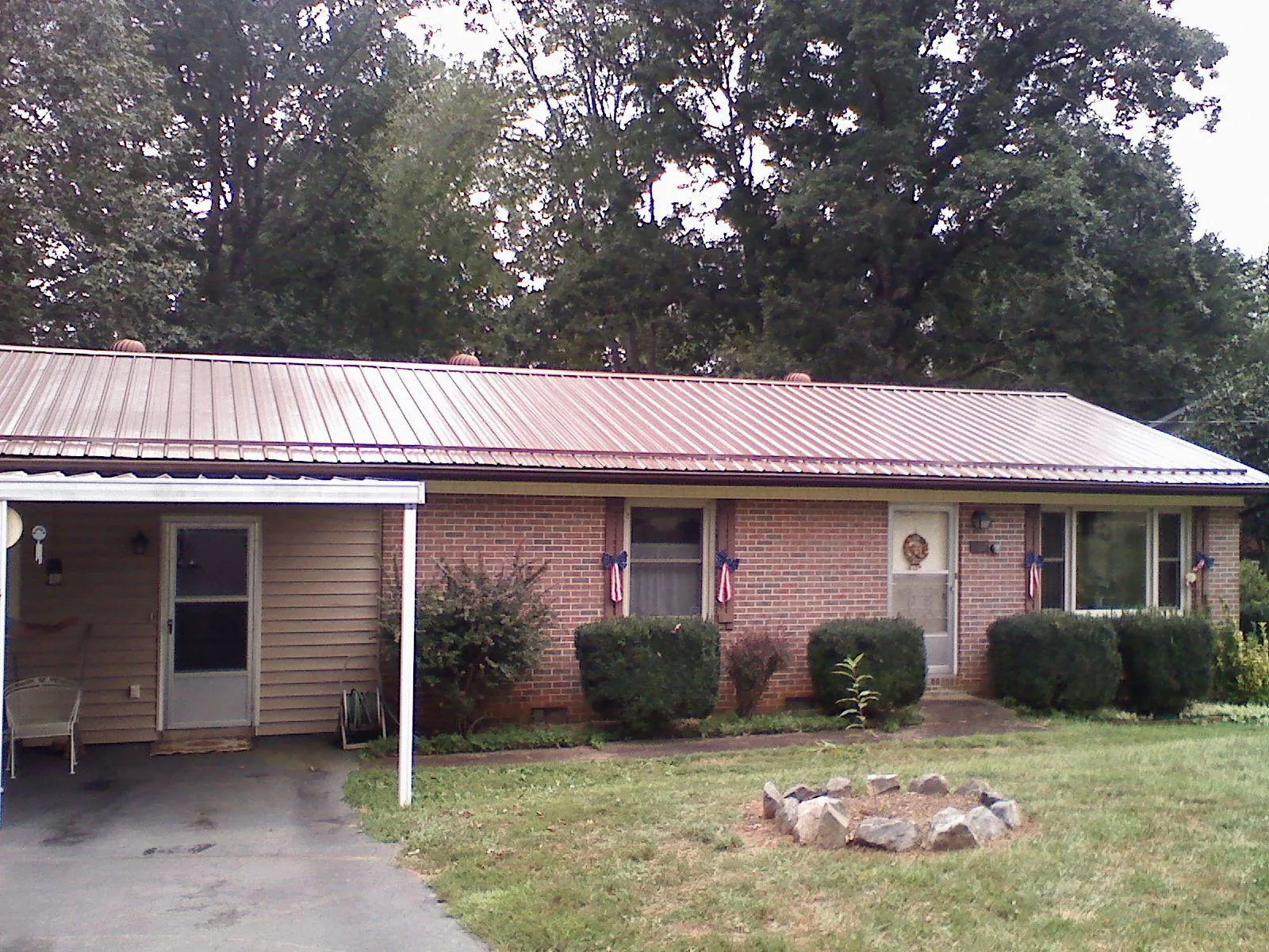 Bronze metal roof and carport on a brick ranch home — Roof Repair work by our crew in Hubbard